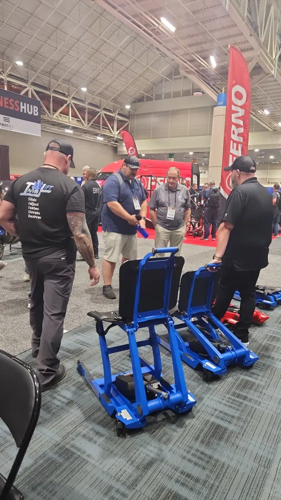 Visitors looking at raised Pro 500 chairs on the EMS World Expo floor