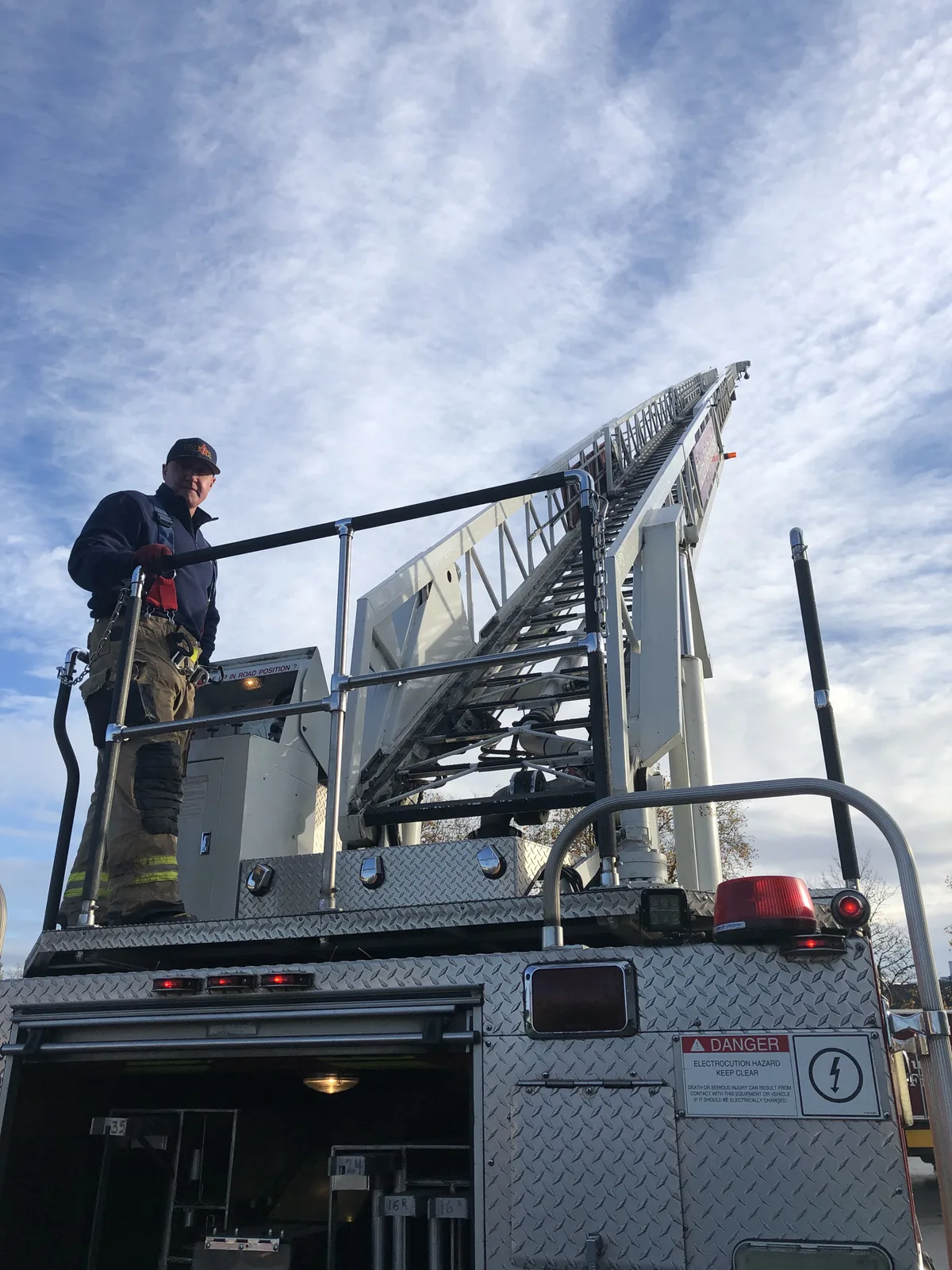 Kevin Comstock on the platform of a fire department ladder truck