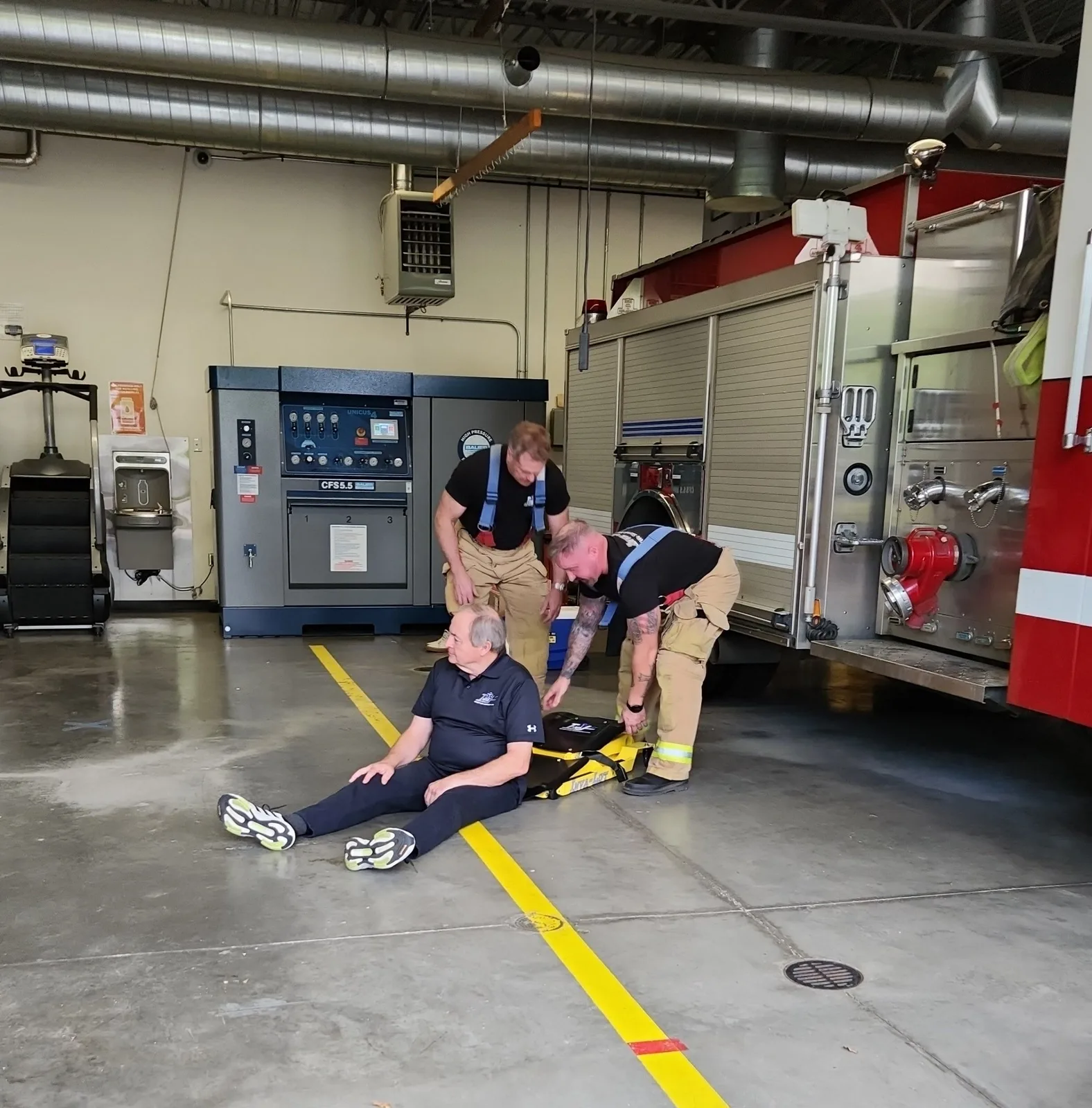 A fire crew demonstrating the chair on the apparatus floor