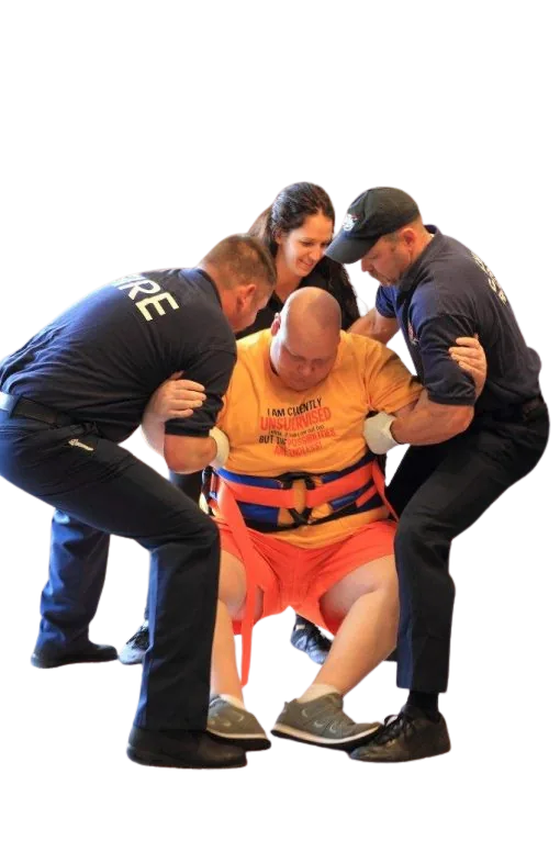 Firefighters manually lifting a person off the floor, risking injury